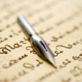 réécriture de chanson : une plume posée sur un papier