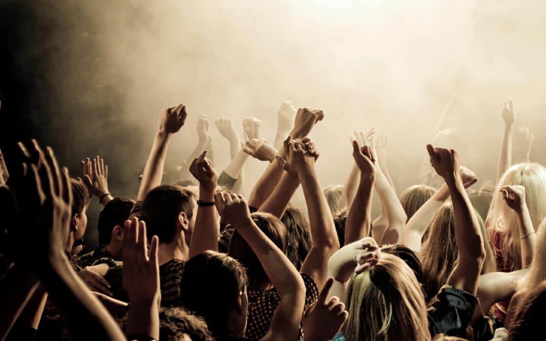 Around the rock : lors d'un concert, dans la fausse, les gens ont les bras levés