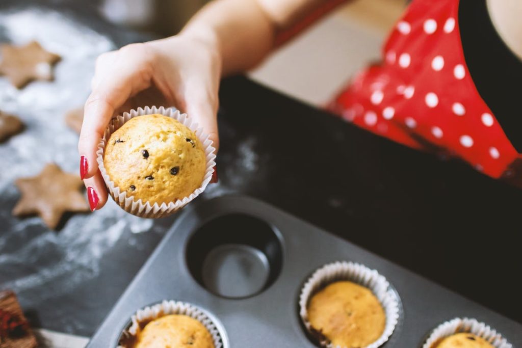 Atelier pâtisserie : une main tient un muffin sorti du four