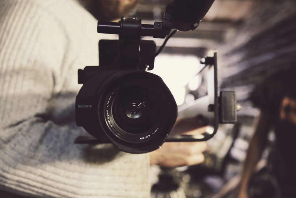 Tournage de film Corporate : un homme tient un appareil photo, l'objectif est de face