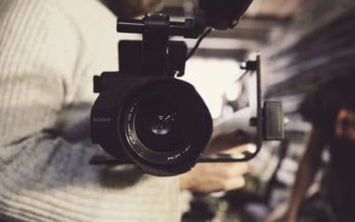 Tournage de film Corporate : un homme tient un appareil photo, l'objectif est de face